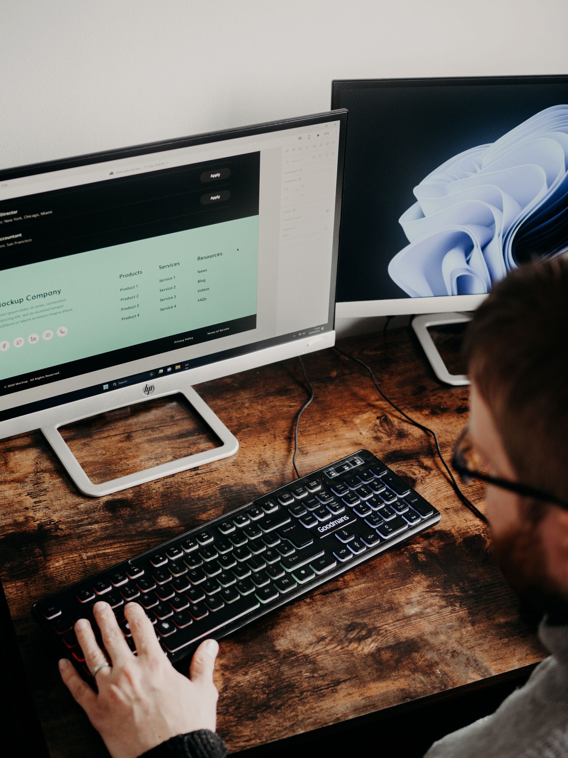 Developer coding on a dual monitor workstation during frontend training